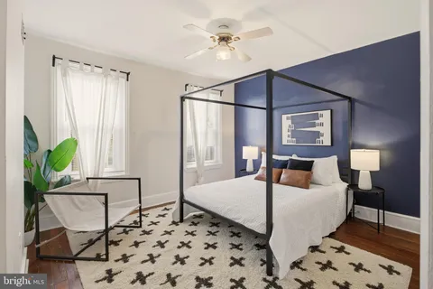 a bedroom with a bed lamp and a potted plant