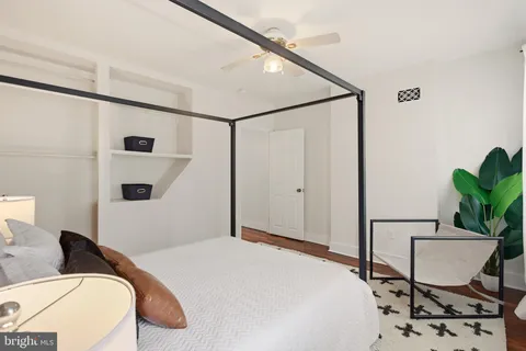 a bedroom with a bed and a chair with the wooden floor