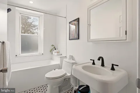 a bathroom with a sink toilet and mirror