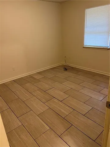 a view of a room with an empty space and wooden floor