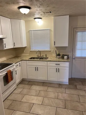 a kitchen with a stove a sink and a refrigerator