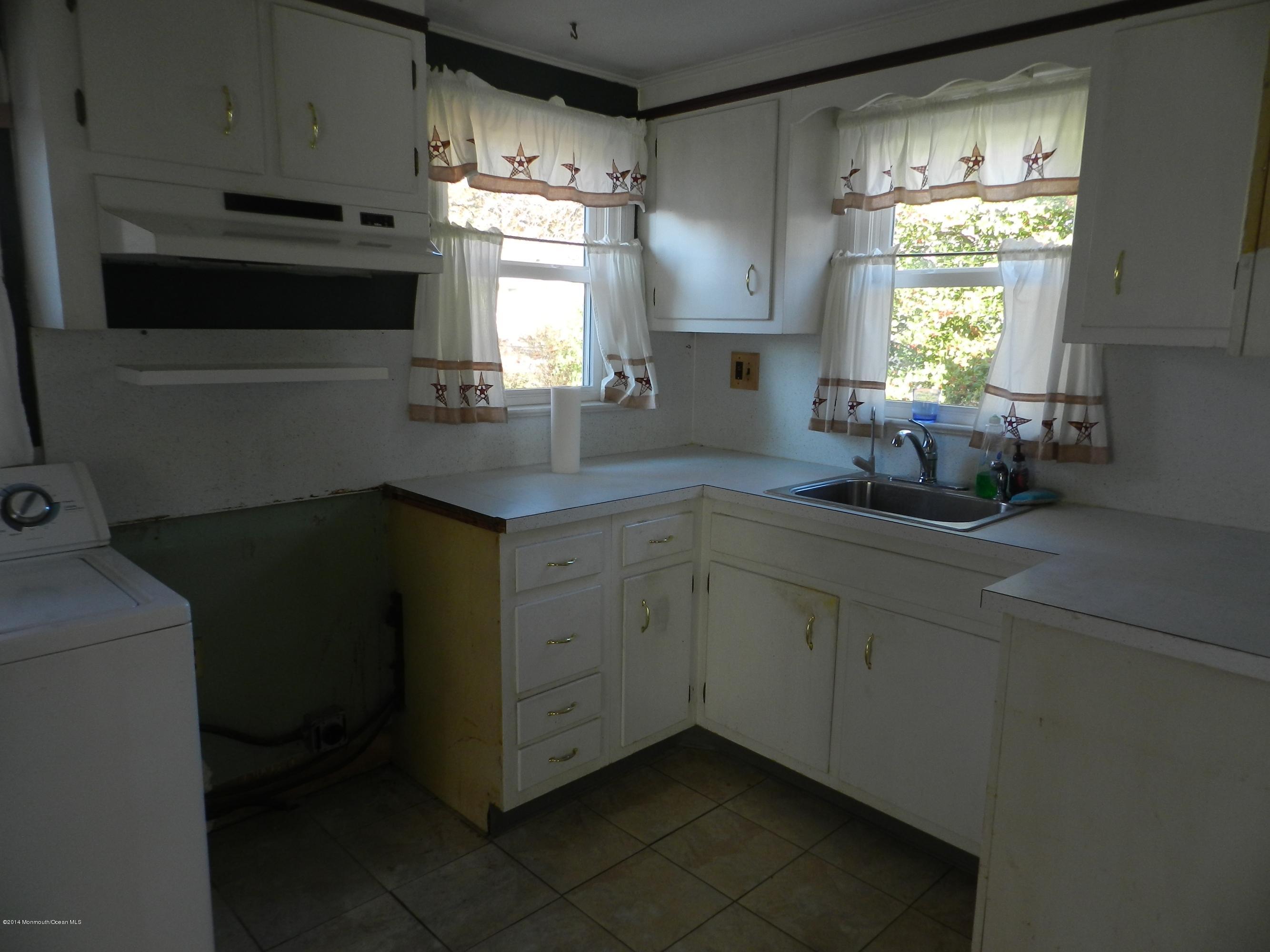 1403 Dorsett Dock Road Point Pleasant, NJ 08742 - Photo 11 of 18 a kitchen with a sink window and cabinets