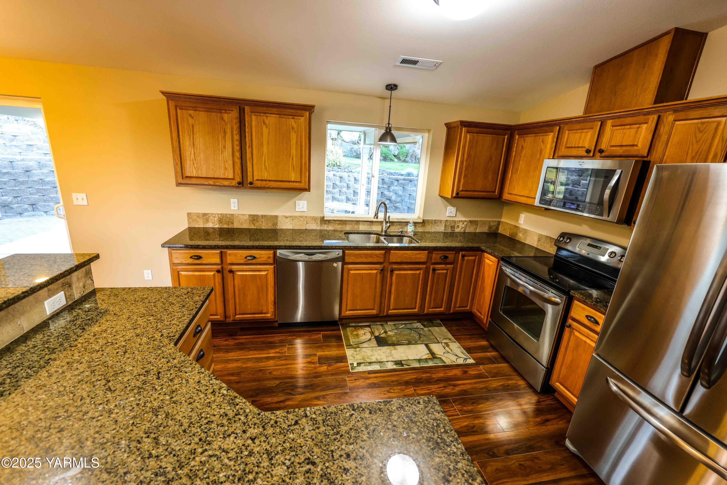 320 Westridge Road Selah, WA 98942 - Photo 22 of 53 a kitchen with stainless steel appliances granite countertop a sink stove and cabinets