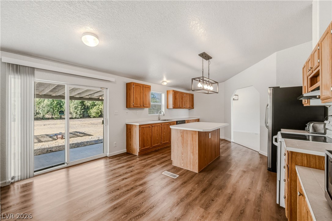 1890 West Dyer Road Pahrump, NV 89048 - Photo 2 of 40 This bright kitchen features an island, hardwood flooring, and direct access to the outdoors.