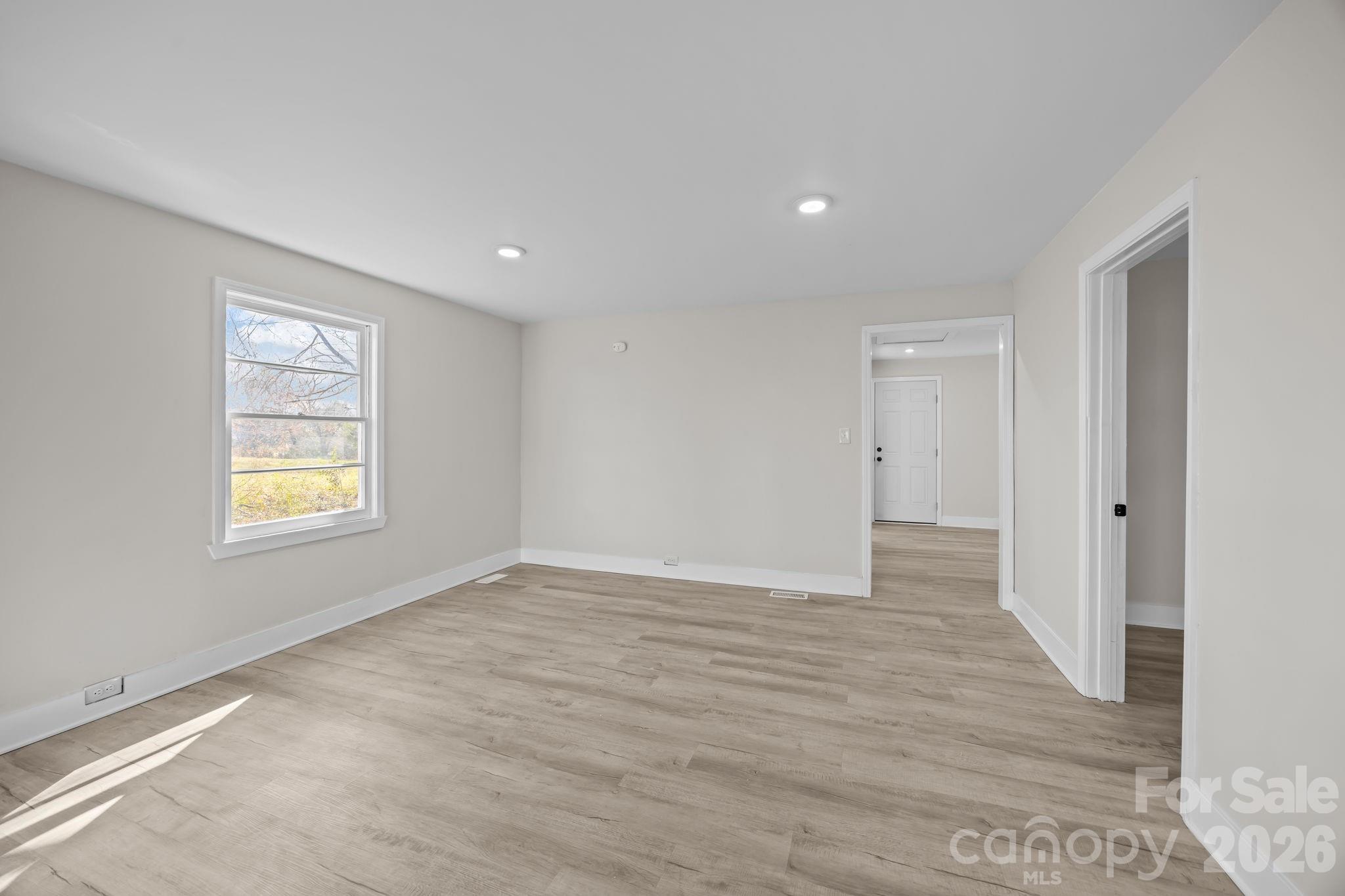 511 East Trade Street Dallas, NC 28034 - Photo 7 of 16 a view of an empty room with wooden floor and a window