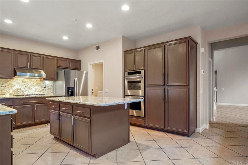 569 Inverlochy Drive Fallbrook, CA 92028 - Photo 15 of 36 a kitchen with stainless steel appliances granite countertop a refrigerator and a sink