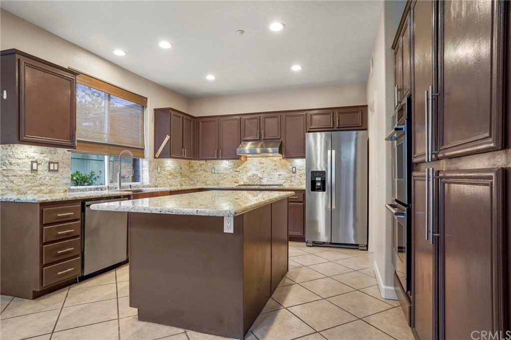 569 Inverlochy Drive Fallbrook, CA 92028 - Photo 16 of 36 a kitchen with stainless steel appliances granite countertop a refrigerator a stove a sink and a microwave
