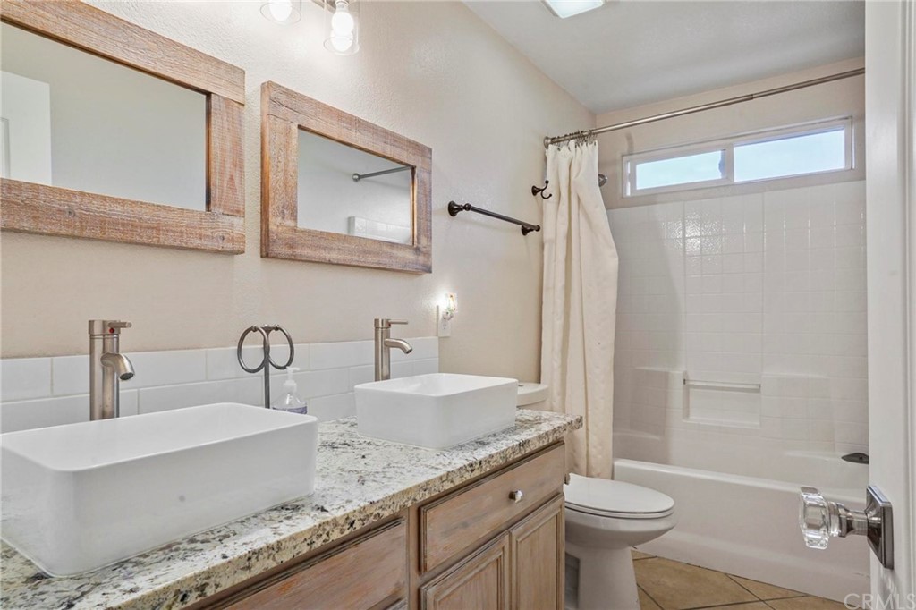 569 Inverlochy Drive Fallbrook, CA 92028 - Photo 27 of 36 a bathroom with a granite countertop sink mirror vanity and toilet