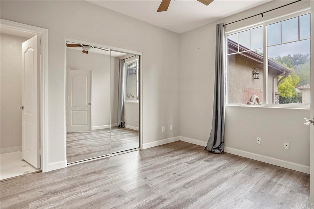 569 Inverlochy Drive Fallbrook, CA 92028 - Photo 29 of 36 an empty room with wooden floor and a window
