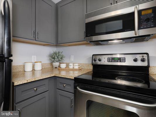 1150 K Street Northwest, Unit 709 Washington, DC 20005 - Photo 14 of 25 a kitchen with stainless steel appliances granite countertop white cabinets and a stove