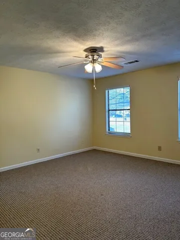 an empty room with a window and a ceiling fan