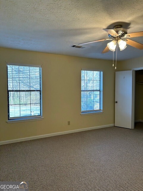 295 Handley Court Tyrone, GA 30290 - Photo 16 of 25 an empty room with a window and a ceiling fan