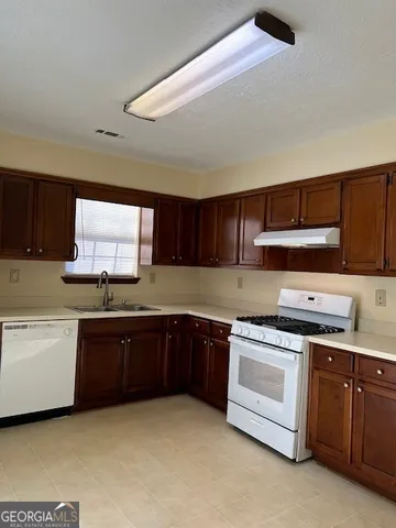 a kitchen with stainless steel appliances granite countertop a stove cabinets and a sink