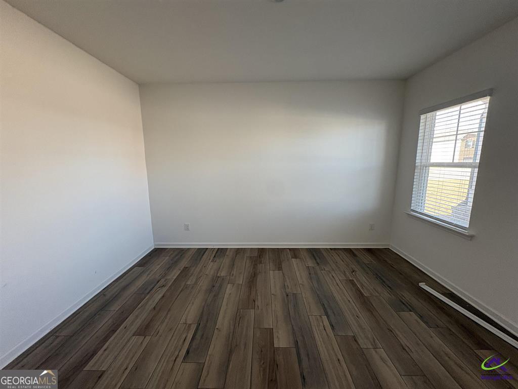 1100 Holland Drive Hampton, GA 30228 - Photo 11 of 15 an empty room with wooden floor and windows
