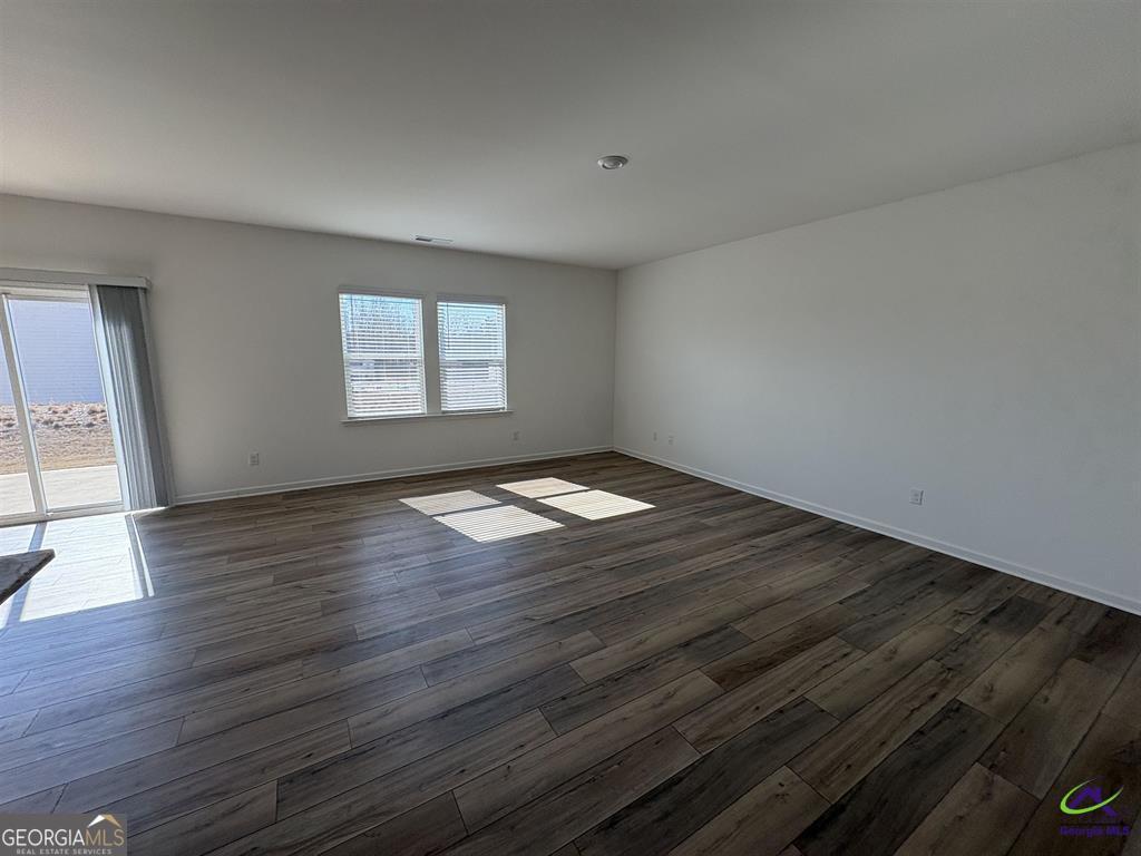 1100 Holland Drive Hampton, GA 30228 - Photo 3 of 15 an empty room with wooden floor and windows