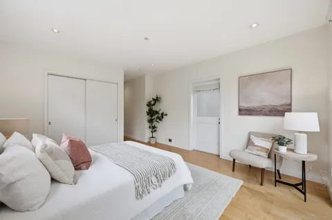a large bed sitting in a bedroom next to a lamp