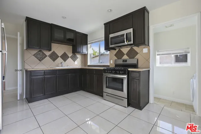 a kitchen with granite countertop a stove and a microwave
