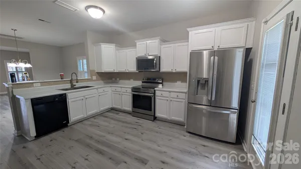 a kitchen with a refrigerator sink and wooden floor