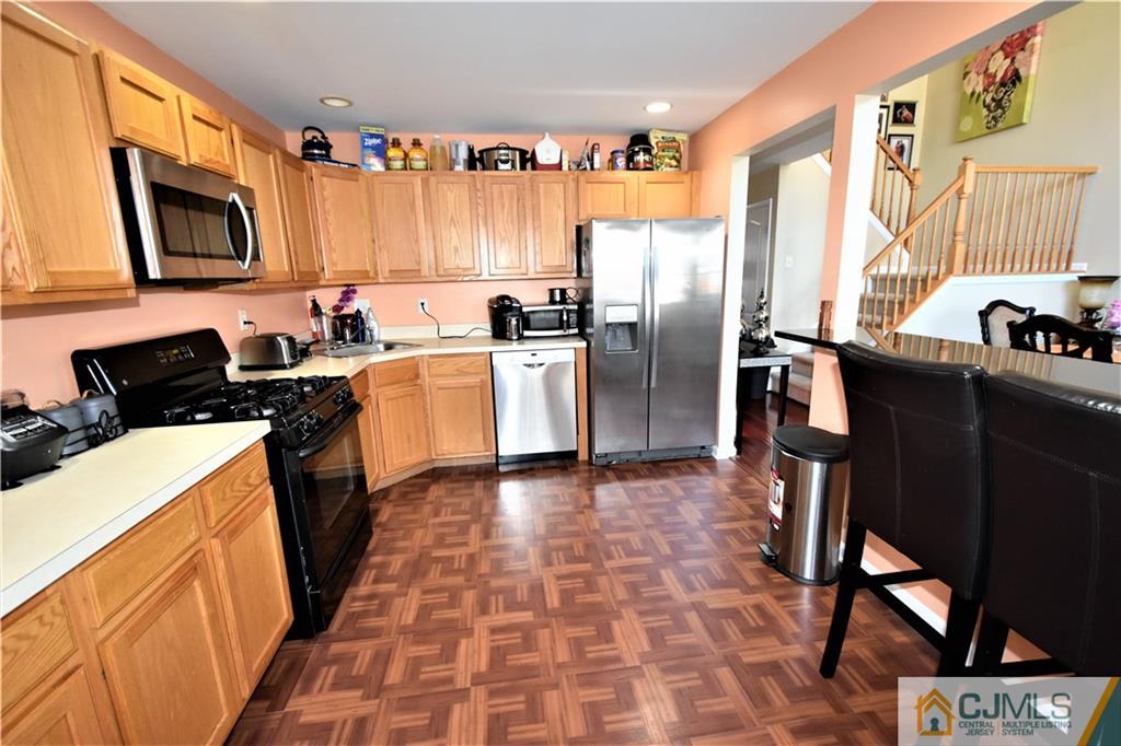 51 Hawthorne Road North Brunswick, NJ 08902 - Photo 8 of 23 a kitchen with stainless steel appliances a stove a sink a microwave a refrigerator and cabinets