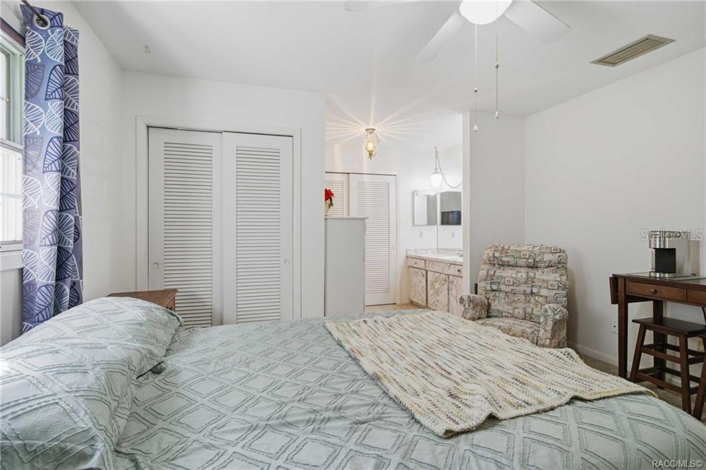 8709 East Sandpiper Drive Inverness, FL 34450 - Photo 12 of 37 a bedroom with a bed and a chandelier