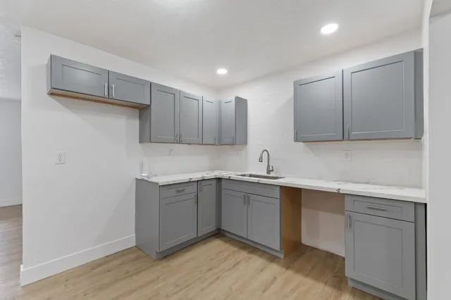 a kitchen with a sink cabinets and wooden floor