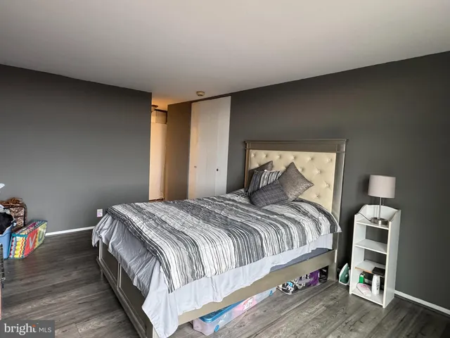 a bedroom with bed and wooden floor