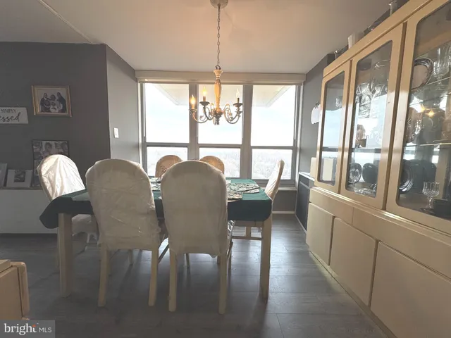 a dining room with furniture a chandelier and wooden floor