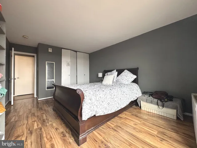 a bedroom with a bed and wooden floor