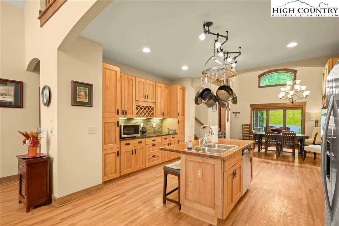 138 South Camp Road, Unit 103 Boone, NC 28607 - Photo 12 of 50 a view of a kitchen with kitchen island stainless steel appliances wooden floor dining table and chairs