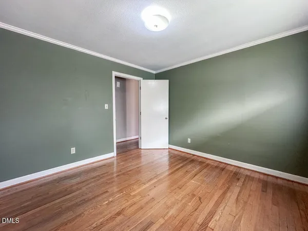 a view of empty room with wooden floor
