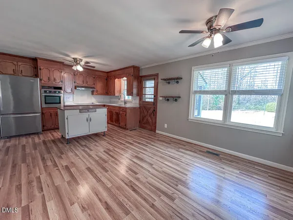 a open kitchen with cabinets stove and a wooden floor