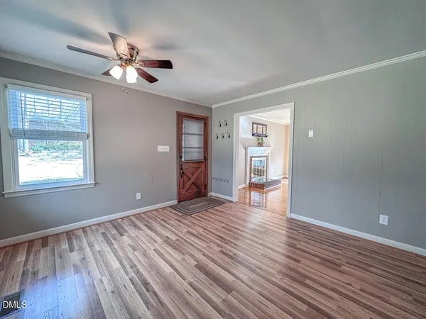 a view of empty room with wooden floor and fan