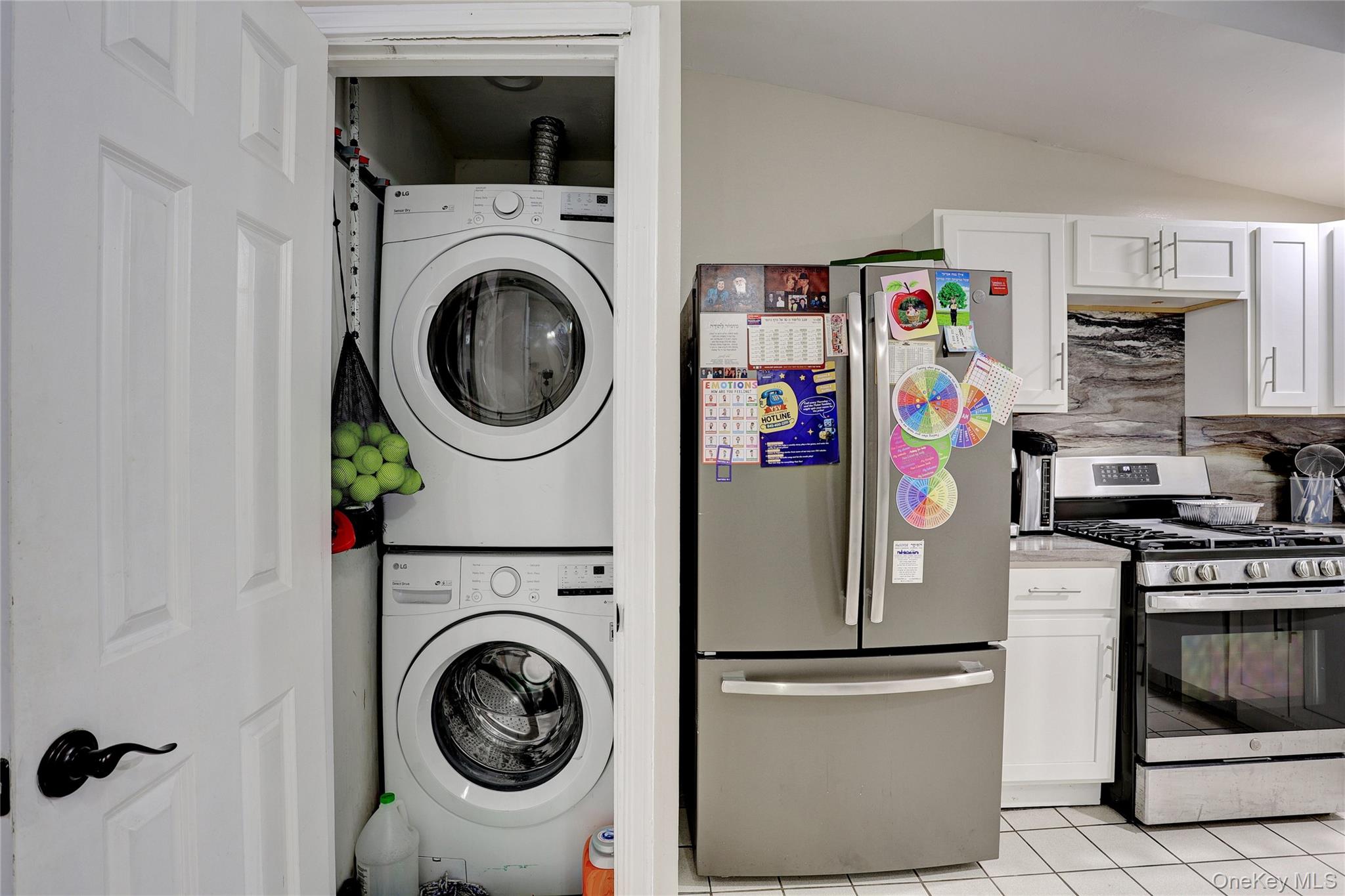 35 Regina Road Monsey, NY 10952 - Photo 13 of 34 Laundry room with stacked washing machine and dryer, vaulted ceiling, and light tile patterned floors