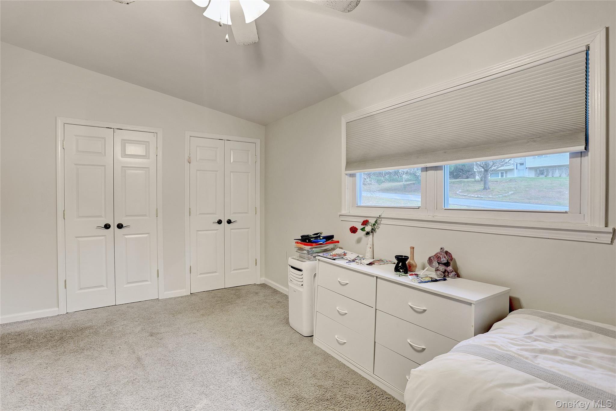 35 Regina Road Monsey, NY 10952 - Photo 17 of 34 Bedroom with two closets, vaulted ceiling, light colored carpet, and a ceiling fan