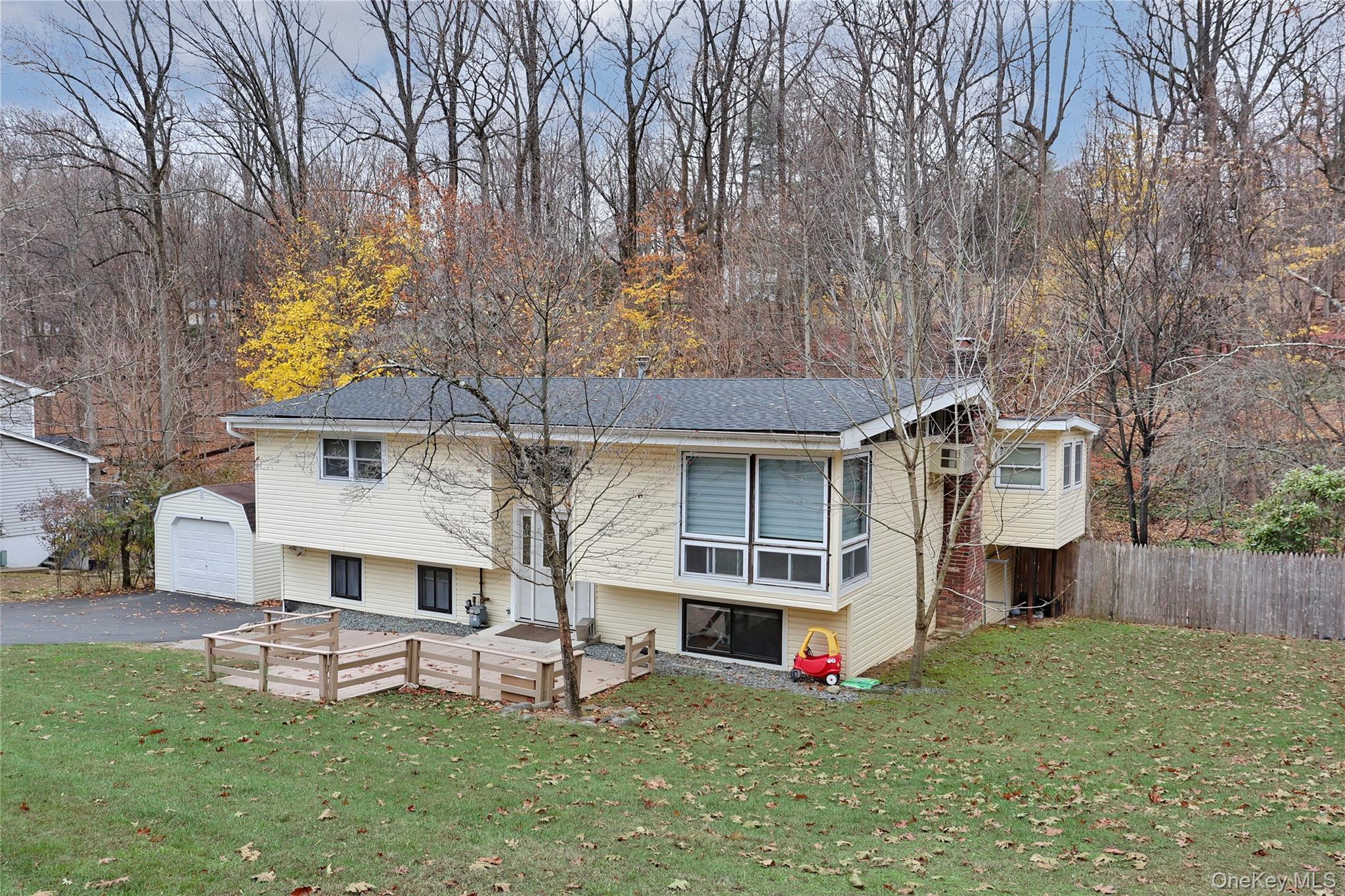 35 Regina Road Monsey, NY 10952 - Photo 33 of 34 Rear view of property with an outdoor structure, a wooden deck, and asphalt driveway