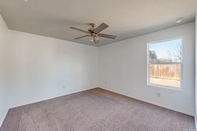 a view of a room with a ceiling fan and entryway