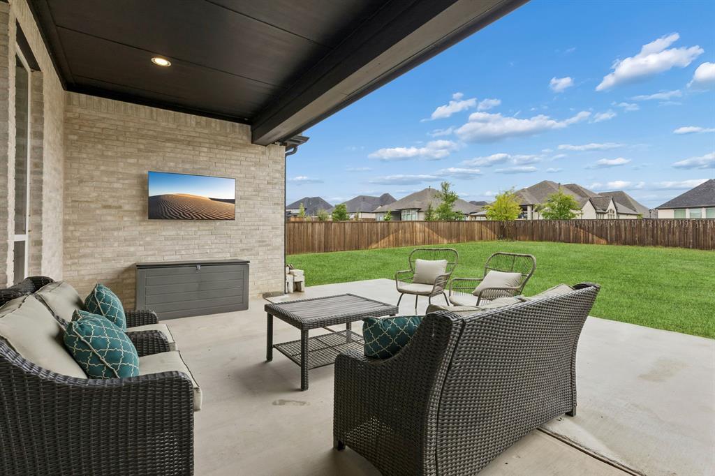 566 Broadleaf Way Haslet, TX 76052 - Photo 32 of 38 Covered patio featuring a light brick exterior and dark soffits