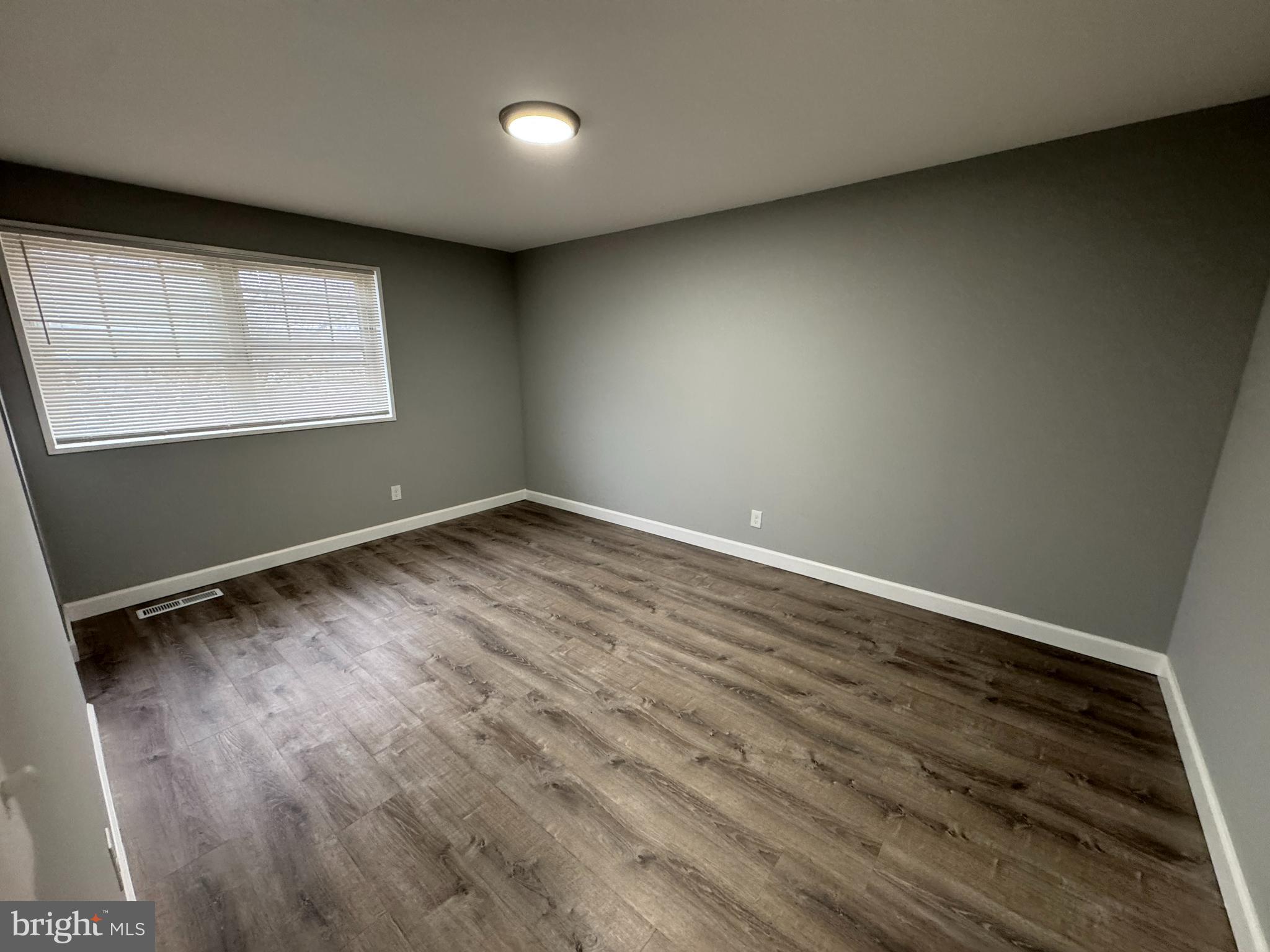 4932 Old Court Road Randallstown, MD 21133 - Photo 4 of 7 an empty room with wooden floor and windows