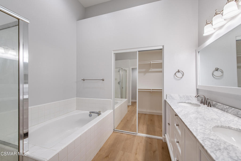 4774 Rhapsody Drive Oak Park, CA 91377 - Photo 15 of 34 a large spacious bathroom with a granite countertop tub sink and mirror