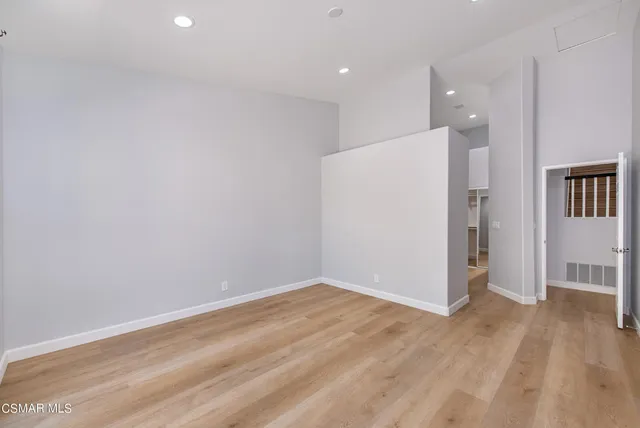 wooden floor in an empty room with a kitchen