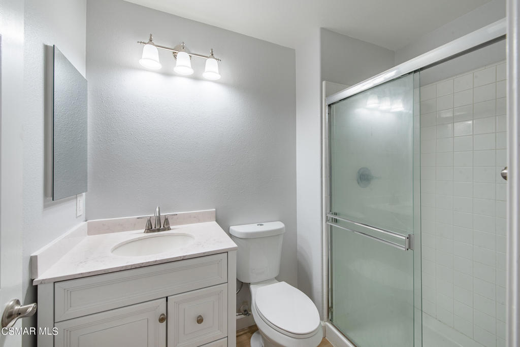4774 Rhapsody Drive Oak Park, CA 91377 - Photo 22 of 34 a bathroom with a toilet a sink and mirror