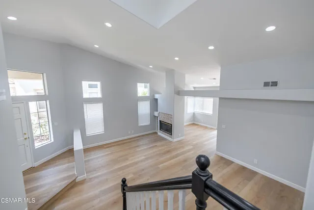 a view of a living room with wooden floor and windows