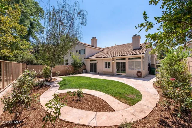 a view of a house with backyard and sitting area