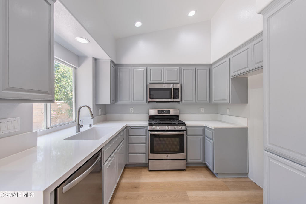 4774 Rhapsody Drive Oak Park, CA 91377 - Photo 7 of 34 a kitchen with stainless steel appliances a sink stove and microwave