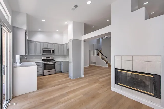 a kitchen with stainless steel appliances kitchen island granite countertop a refrigerator and a stove top oven