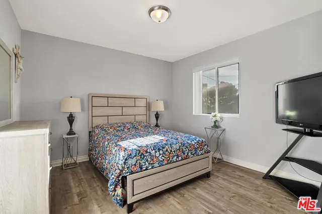 a bedroom with a bed flat screen tv and a window