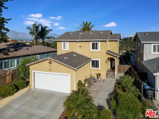an aerial view of a house with a yard and large tree