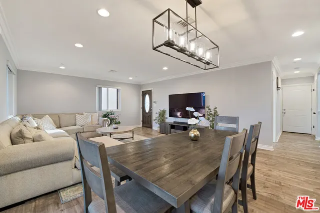 a view of a dining room with furniture a chandelier and wooden floor
