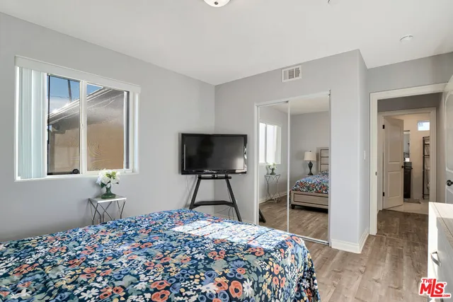 a bedroom with a bed and a flat screen tv