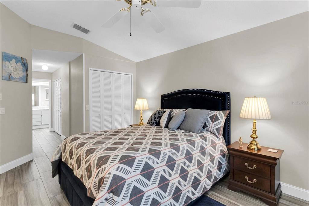 4638 Sheffield Drive New Port Richey, FL 34655 - Photo 18 of 67 a bedroom with a bed and a lamp on dresser